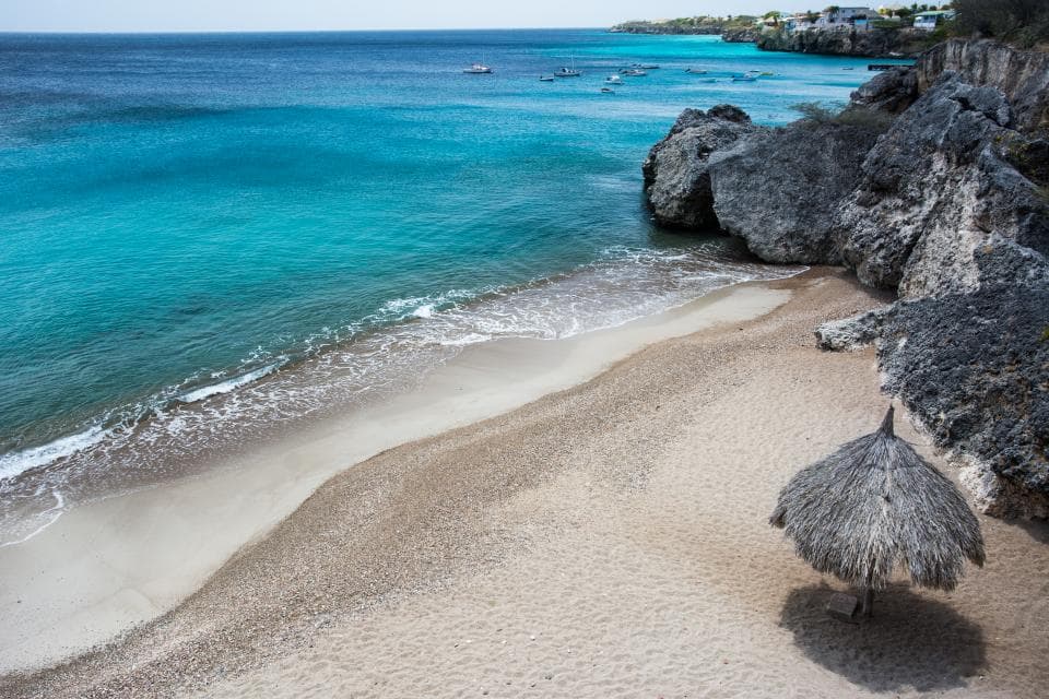 Playa caribeña de arena clara con agua turquesa.